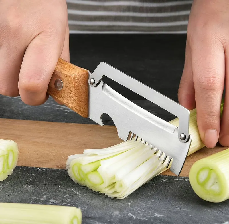 PeelPro op een houten snijplank naast dunne reepjes prei in julienne